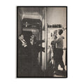 Black and white photo of three men breaking down a door while a couple dances inside.