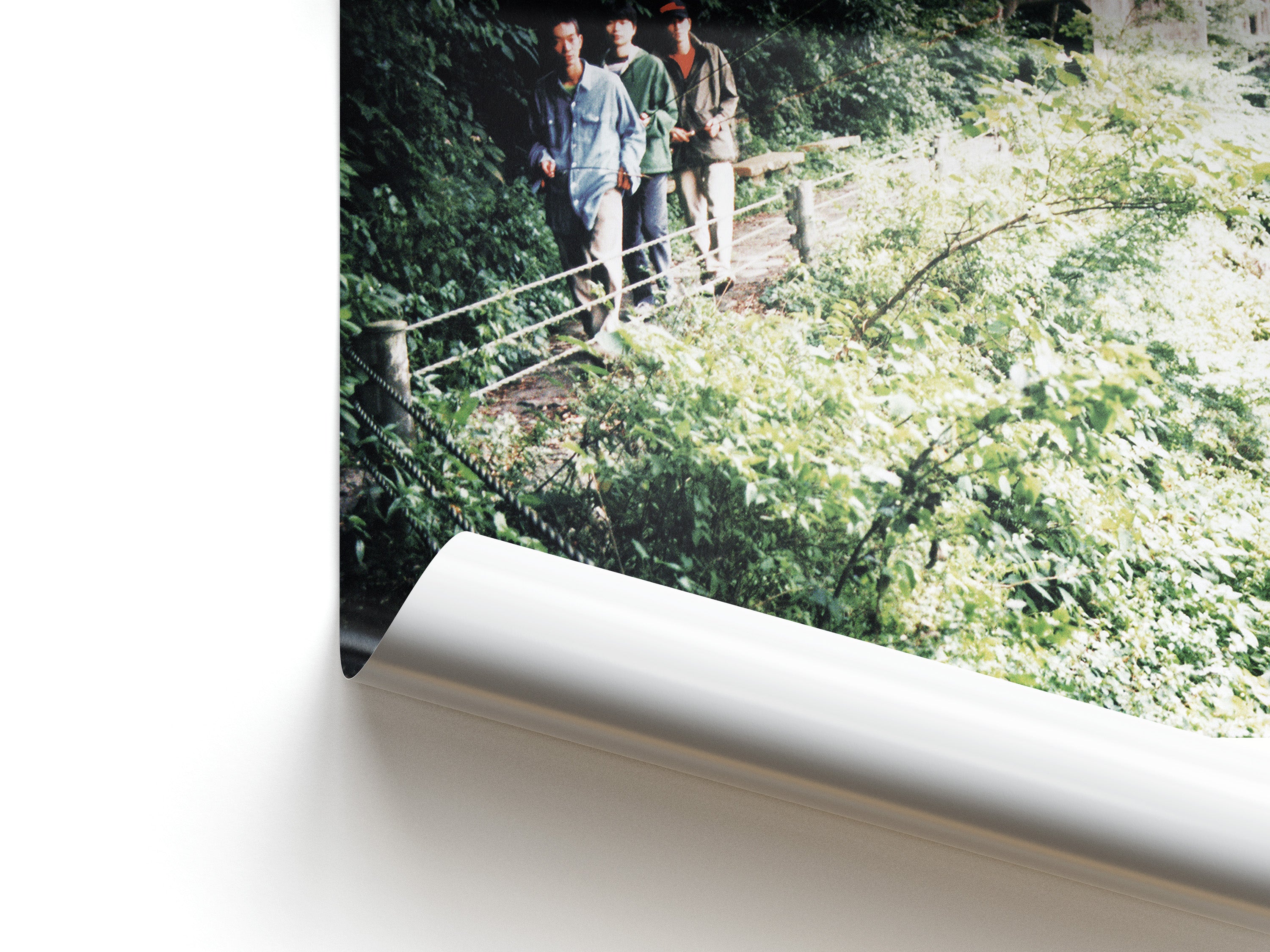 Two people standing on a wooden bridge over a lush green landscape.
