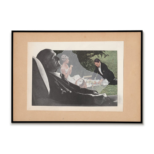 Framed black and white photograph of a man sitting outdoors with a woman and child, on a white background.
