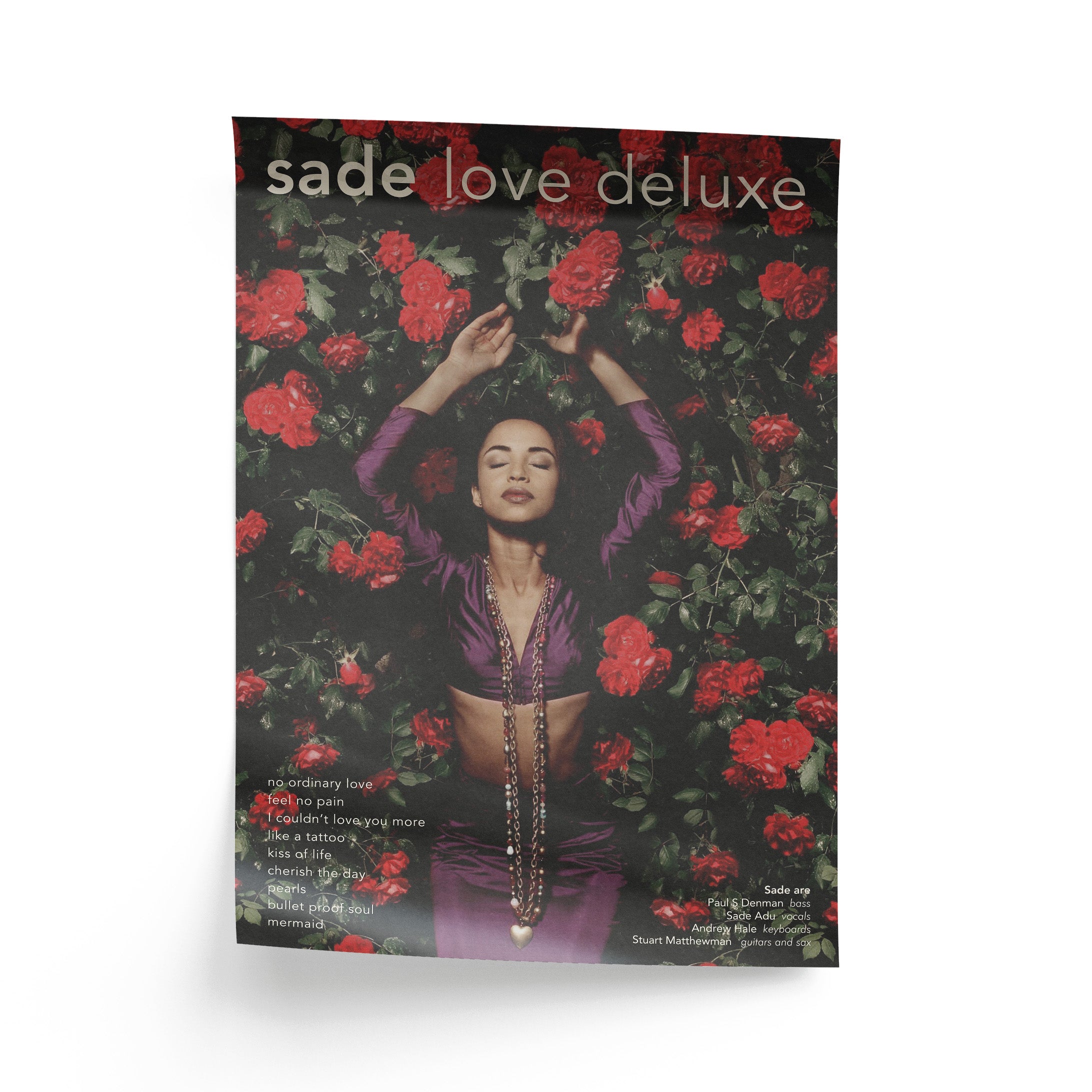 Album poster for 'sade love deluxe' with a person surrounded by red roses on a black background.