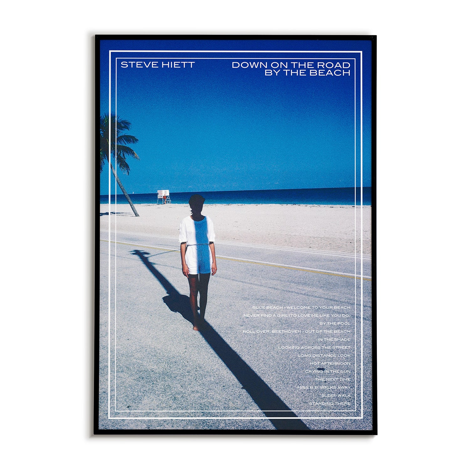 Poster of a person standing on a road with a beach and palm tree in the background. 